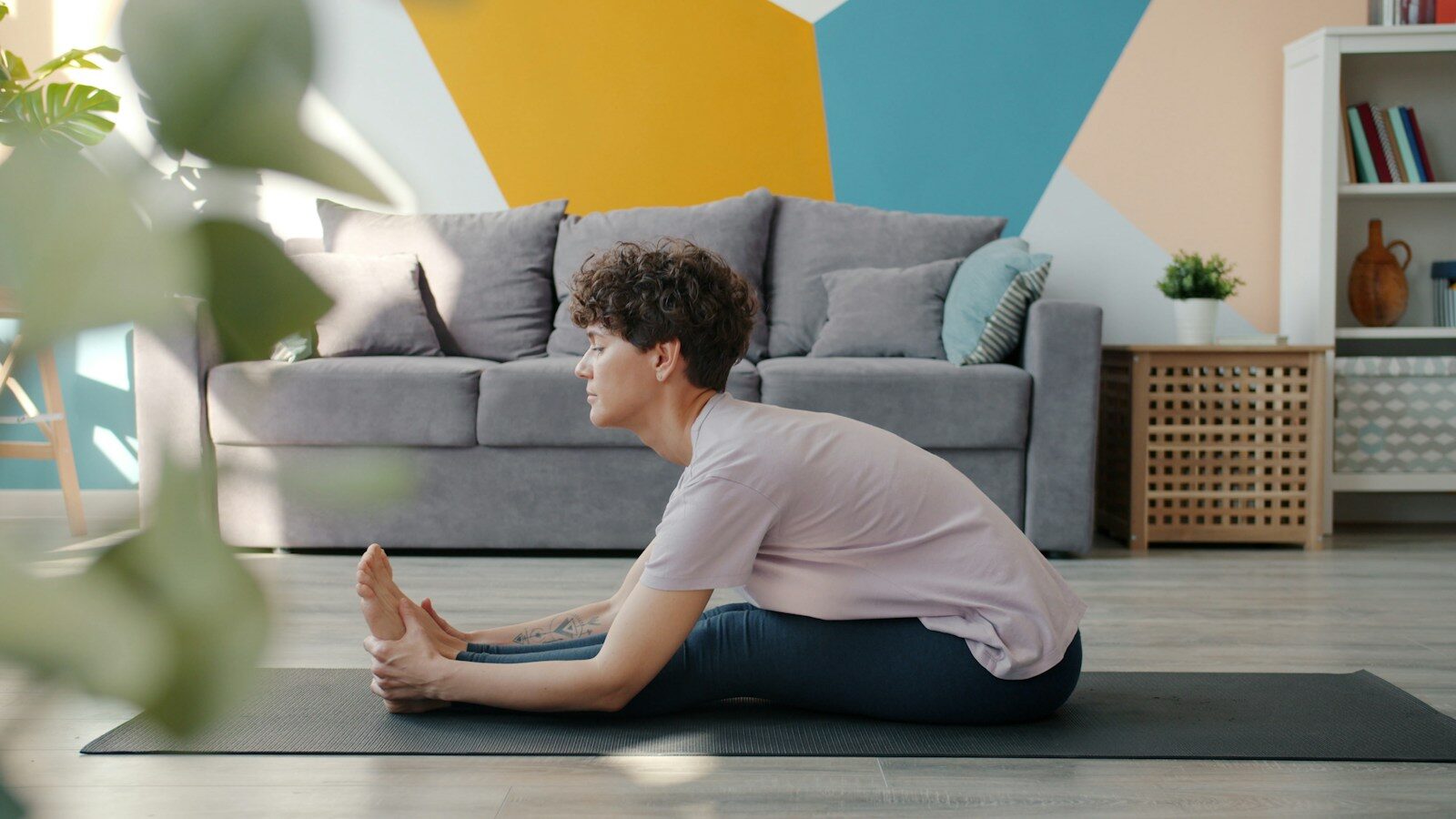 Woman stretching on yoga mat in living room